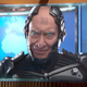 A bald android with piercing sky-blue eyes and a disconcerting smile addresses people on TV.